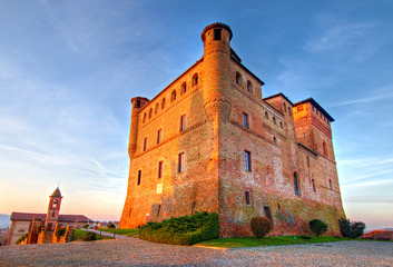 Golden hour view of Grinzane Cavour castle, historical landmark, village in Langhe region, Cuneo, Piedmont, Italy. 