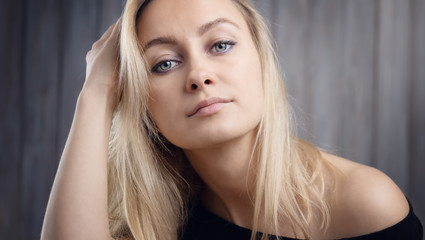 Fototapeta premium Happy beautiful young blond woman portrait with wooden background