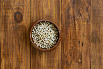 Chickpeas in a bowl on a brown wooden table. Horizontal orientation, copy space.