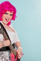 Portrait of a young woman playing guitar over colored background