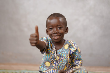 Unbelievably happy African black boy with Thumbs Up and Copy Space