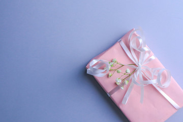 Beautiful gift box and flowers on light background