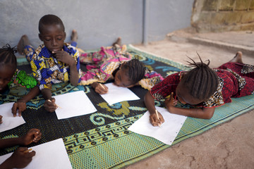 Four African Children educating and drawing, writing indoors