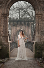 Lovely young lady wearing elegant white dress enjoying the beams of celestial light and snowflakes...