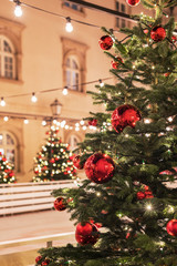 Christmas tree with red balls on a blurred city background, decorated for New Year