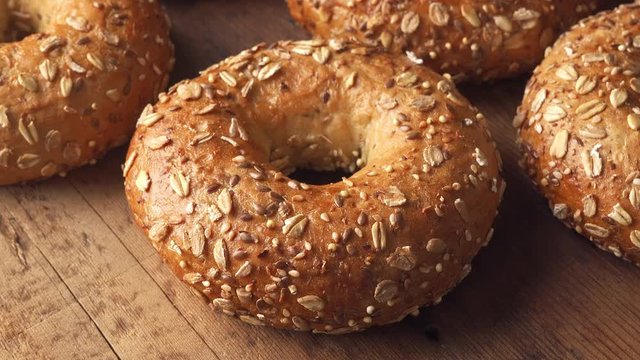 Whole grain bagels on a rustic wood table top.