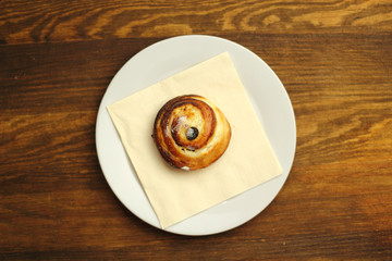 Bread Roll with raisins and cottage cheese filling on a wooden plank table