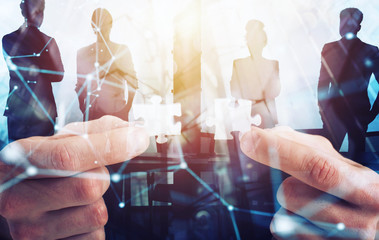 Businessman join two puzzle pieces. Concept of teamwork and partnership. double exposure with light...