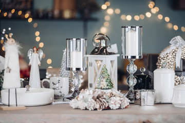 Close-up table with Christmas fairytale decoration amazing flashing garland holiday mood. Modern room with different New Year interior decoration ready celebrating december winter greetings front view