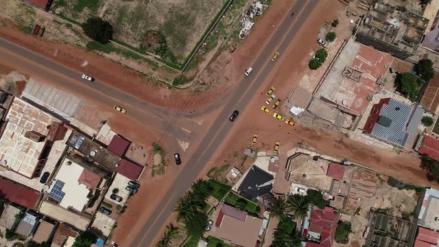 Aerial drone birds-eye view of T Junction on Kololi Road in Serrekunda The Gambia Africa with moving traffic and cars