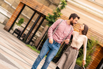 A man and a woman on the street of an old town, enjoying a wonderful day.