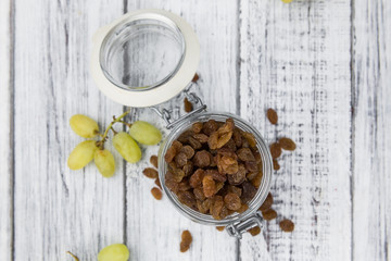 Portion of healthy Raisins on an old wooden table (selective focus; close-up shot)