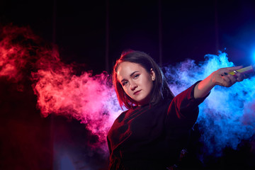 Teenage chubby girl with colored smoke torch in hand during photoshoot with colored smoke at night...
