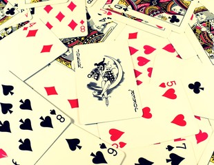 the joker card lies at the center of the scattered playing cards