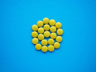 The flag of Palau made of yellow candy on blue solid ackground.