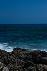 Fototapeta na wymiar Mar estrellando contra piedras en la playa