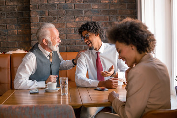 Three people having a business meeting, about to conclude a business deal.