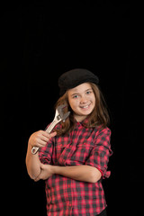 Retrato de estudio de una niña con ropa de trabajadora. Fondo negro
