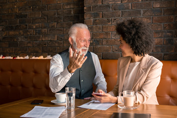 A senior colleague coaching and supporting a talented young business woman in a warm rustic atmosphere.