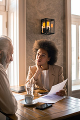 An insurance professional reviewing the details of the contract with an elderly man.