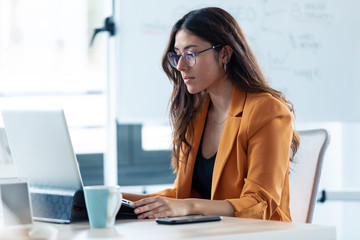 Business young woman working with laptop in the office.