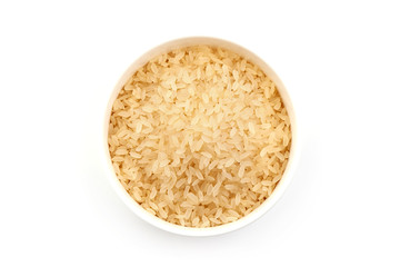 Parboiled rice in a bowl, isolated on white background