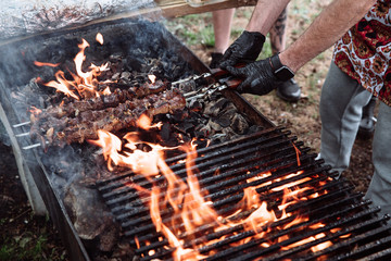 The cook prepares meat-kebab.