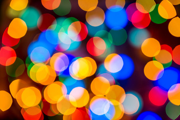 Christmas colorful bright background. Festive abstract bokeh defocused large colored lights garland on black background. Copy space