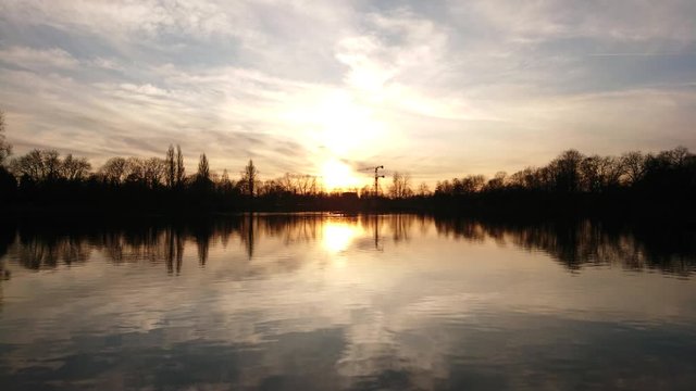 Timelapse of sunset and moving clouds over the lake