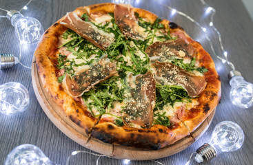 Delicious tasty pizza with ingredients on wooden table