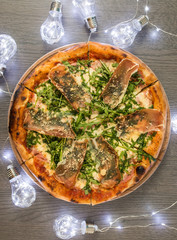 Delicious tasty pizza with ingredients on wooden table