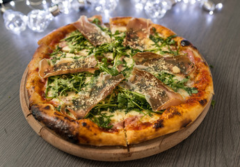 Delicious tasty pizza with ingredients on wooden table