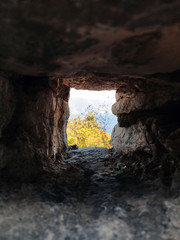 Stone window in ancient church. Summer sea landscape and brick wall