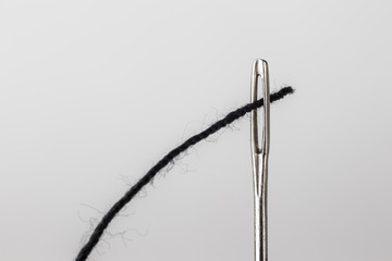 Needle and black thread close up