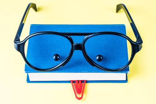 Book, glasses, paperclip and buttons look like face
