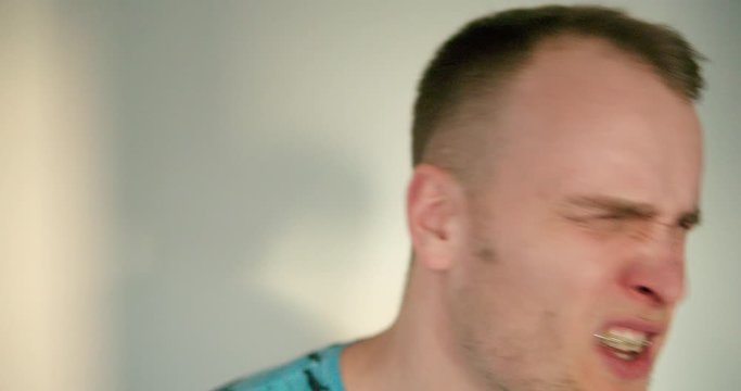 Man is hitting himself with his hand in this face in slow motion