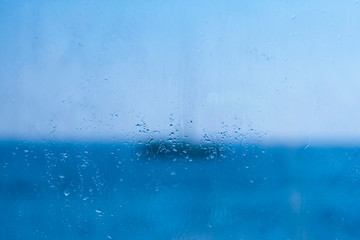 Naklejka na ściany i meble Blue window glass with drops and blurs