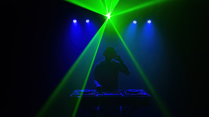 DJ - Silhouette of the man Disc jockey . Disco lights and laser