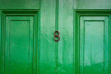 House number 8 on an elegant green wooden front door