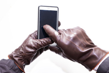 Leather gloves touch and smartphone. White background, isolated
