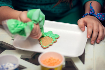 Obraz na płótnie Canvas Children doing christmas decoration with hand made cookies