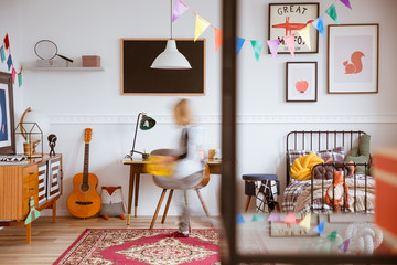 Cute vintage style posters on white wall of trendy bedroom for child