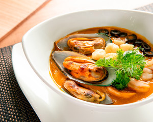 Appetizing seafood soup with clams and black olives