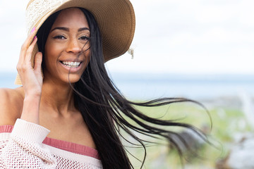 Pretty African American woman with long black hair at the beach