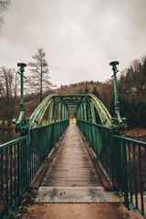 Fototapeta premium Old green metal bridge with wooden path.