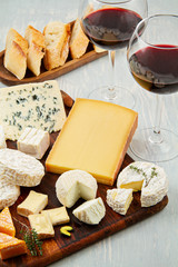 French cheese plate and a glass of wine for buffet party. Traditional french and italian entires