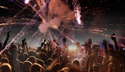 crowd with raised hands at concert festival banner