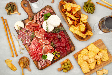 Appetizers table with differents antipasti, charcuterie, snacks and wine. Sausage, ham, tapas, olives, cheese and crackers for buffet party
