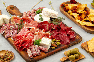 Appetizers table with differents antipasti, charcuterie, snacks and wine. Sausage, ham, tapas, olives, cheese and crackers for buffet party
