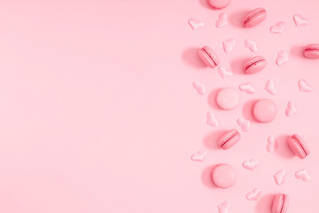 Elegant composition for Valentine's day. Pink macaroons and confetti hearts on pastel pink background. Valentine day concept. Flat lay, top view, copy space